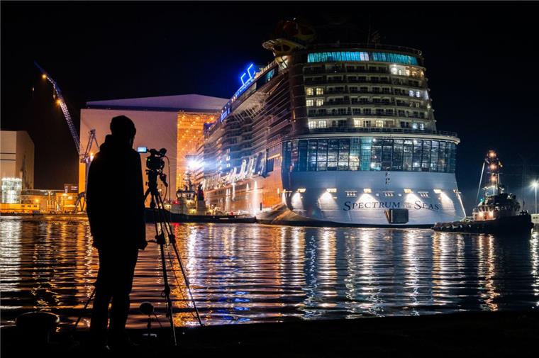 Bremerhaven: "Spectrum of the Seas" bald am Kreuzfahrtterminal Ein Mann mit einer Filmkamera auf einem Stativ steht vor dem Hafenbecken und beobachtet das Kreuzfahrtschiff "Spectrum of the Seas"
