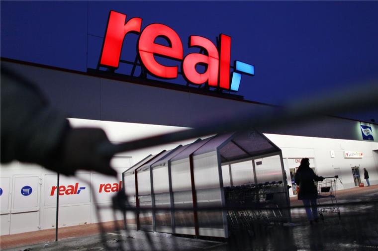 Streik bei Real-Märkten am Montag Ein Mann schiebt seinen Einkaufswagen vor einem Real-Markt.