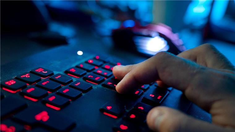 Ein Mann sitzt am Rechner und tippt auf einer Tastatur.