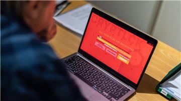 Ein Mann sitzt vor einem Laptop, der mit einem Verschlüsselungstrojaner (Ransomware) befallen ist.