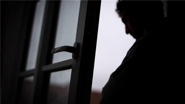 Krankenkasse: Hohe Zahl an psychisch erkrankten Jugendlichen Ein Mann steht am offenen Fenster seiner Wohnung.