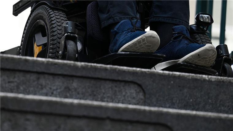 Abgeordnete mit Behinderungen vernetzen sich Ein Mann steht mit seinem Rollstuhl vor der Treppe eines Eingangs zur U-Bahn.
