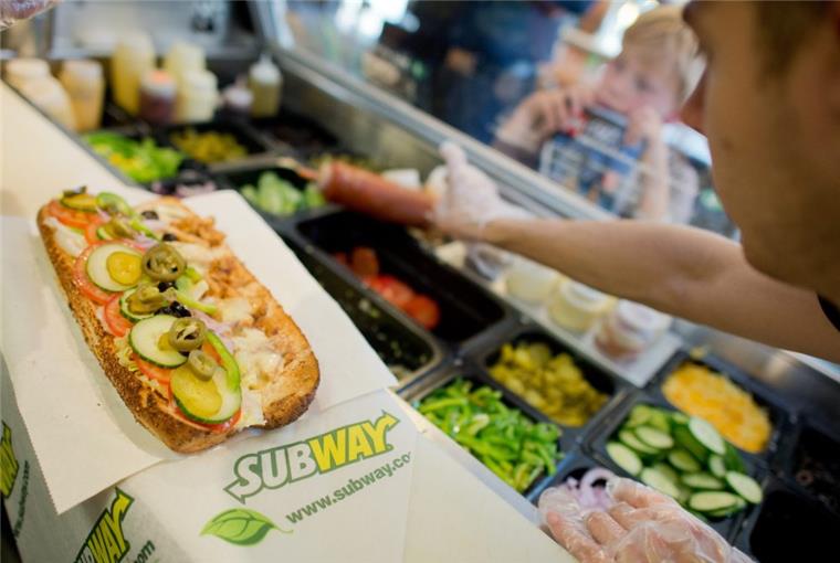 Subway-Eröffnung in Bremerhaven: Es tut sich was Ein Mitarbeiter belegt einen Sandwich in einer Filiale der Fast-Food-Kette Subway.