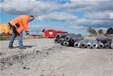 Ein Mitarbeiter der Straßenmeisterei zeigt auf die alten Betonplatten, die entfernt werden müssen.