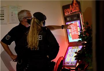 Ein Mitarbeiter des Ordnungsamtes und eine Polizistin sehen sich in Essen während einer Razzia einen Spielautomaten an.