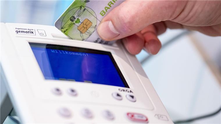 Trotz Startschwierigkeiten: E-Rezept landesweit viel genutzt Ein Mitarbeiter einer Apotheke steckt eine Gesundheitskarte in ein Lesegerät.