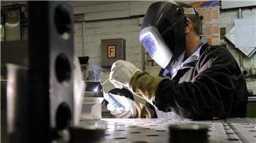 Ein Mitarbeiter eines metallverarbeitenden Betriebes in Kiel schweißt eine Naht an einem Werkstück.