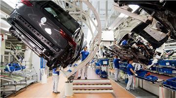 Ein neuer Volkswagen Golf 8 (l) schwebt an einer Produktionslinie im VW Werk.