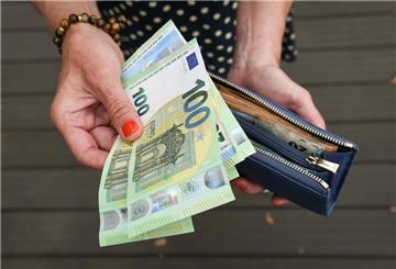 Eine Frau hält verschiedene Geldscheine in der Hand