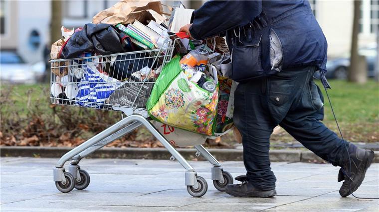 Armutskonferenz fordert Aktionsplan gegen Wohnungslosigkeit Ein obdachloser Mann schiebt einen Einkaufswagen über eine Fußgängerstraße in Berlin.