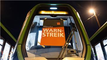 Ein Plakat mit der Aufschrift „Warnstreik“ hängt an einer Stadtbahn.