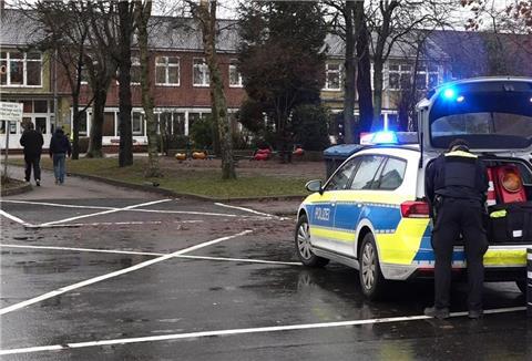 Ein Polizeiauto steht vor dem Gebäude einer Grund- und Hauptschule in Lüdingworth. Dort hat ein Mädchen ein anderes mit einem Messer schwer verletzt.