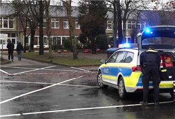 Ein Polizeiauto steht vor dem Gebäude einer Grund- und Hauptschule in Lüdingworth. Dort hat ein Mädchen ein anderes mit einem Messer schwer verletzt.