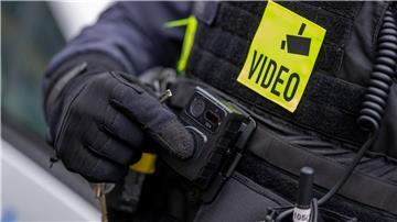 Ein Polizist schaltet die Bodycam auf seiner Uniform ein.