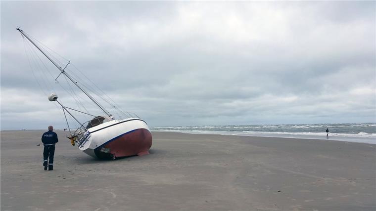 Segler stranden nachts an Borkumer Strand Ein Polizist steht neben dem auf Borkum gestrandeten Segelboot.