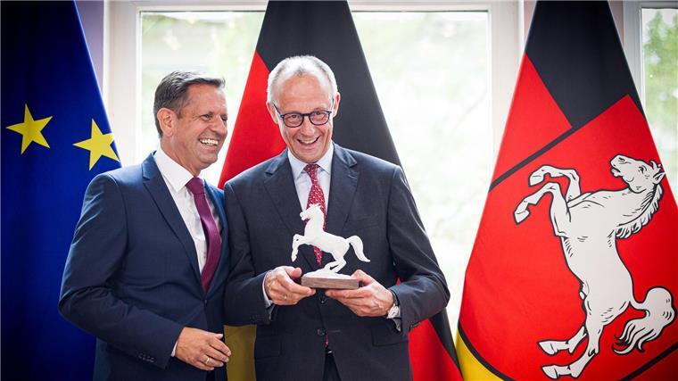 Merz in Niedersachsen: Industrie, Investitionen – und Pferde Ein Ross für den Kanzler: Lies (l) überreicht Merz eine Pferdeskulptur – passend zur Krawatte mit Landeswappen-Motiv.