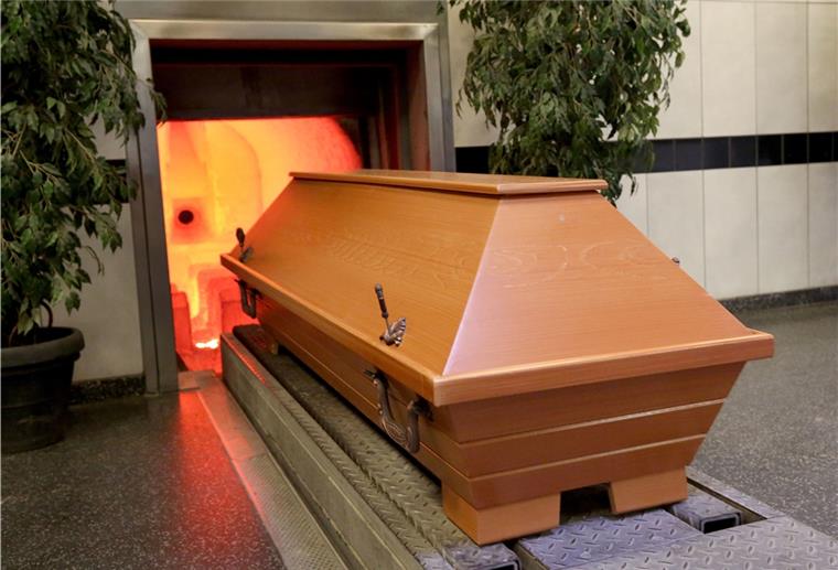 Heikles Thema: Bestattungen in Corona-Zeiten Ein Sarg wird in den rund 850 Grad heißen Krematoriumsofen gefahren. Grundsätzlich haben Angehörige auch in der Corona-Krise die Wahl zwischen den beiden Bestattungsarten Erd- und Feuerbestattung. Allerdings sind Trauerfeiern und andere Zeremonien des Abschiednehmens derzeit nur begrenzt möglich.