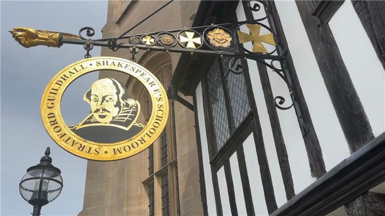 Ein Schild an einem historischen Gebäude (Guildhall) in der englischen Stadt Stratford-upon-Avon erinnert an den Schriftsteller William Shakespeare.