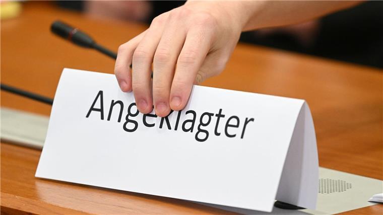 Prozess um Doppelmord: Anklage fordert lebenslange Haft Ein Schild mit der Aufschrift „Angeklagter“ wird auf die Gerichtsbank gestellt.