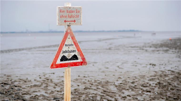 Wattenmeer seit 15 Jahren Weltnaturerbe Ein Schild mit der Aufschrift „Vorsicht Jadebusen“ steht im Wattboden am Strand von Dangast.