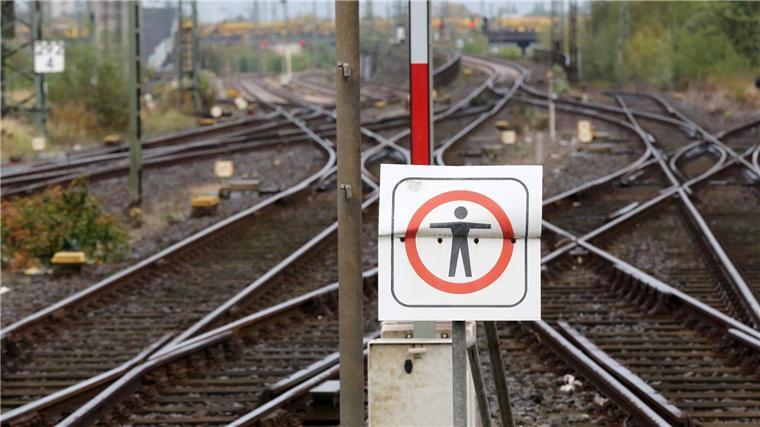Ein Schild mit einem Symbol für „Nicht betreten“ ist vor Gleisanlagen zu sehen.