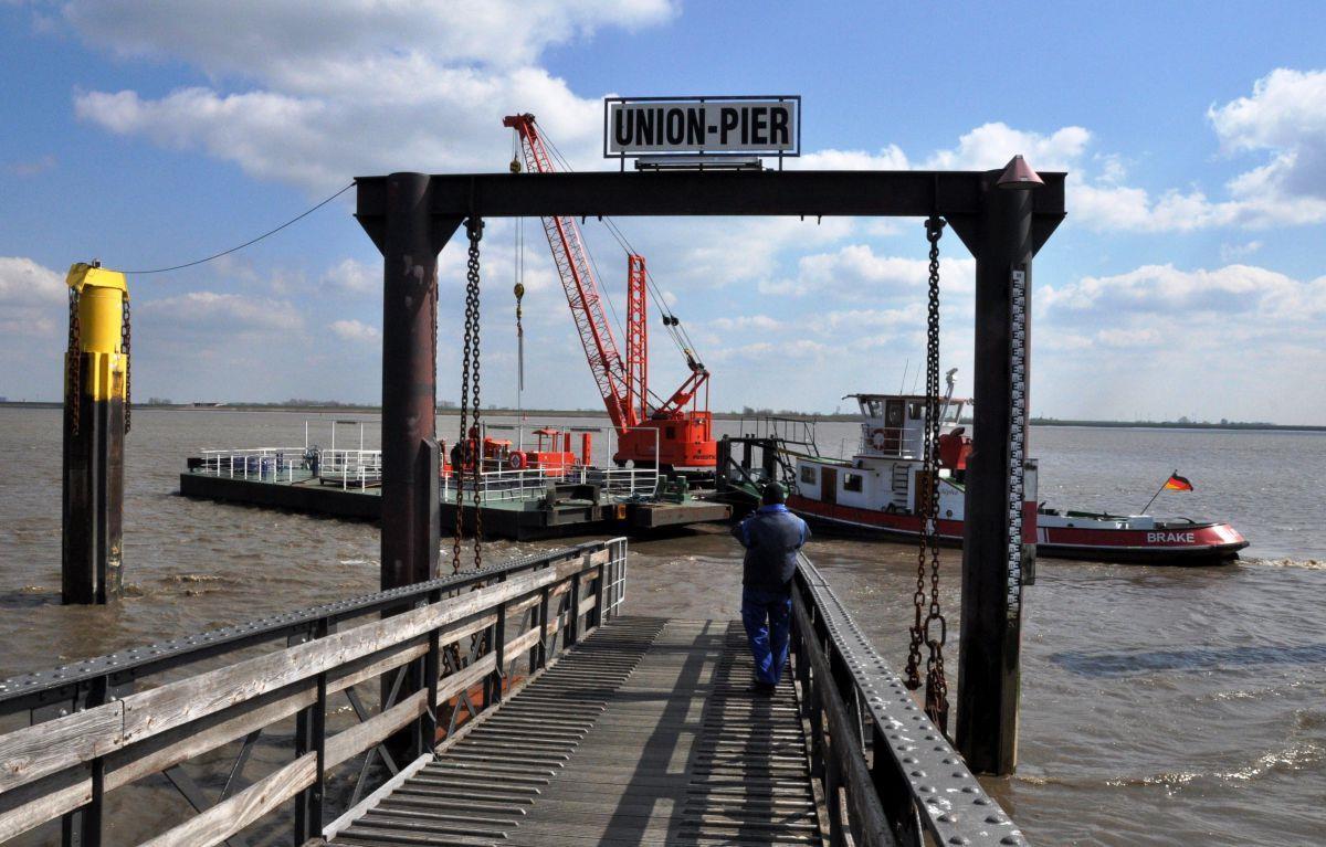Ein Schlepper nimmt den Ponton des Unionpiers in Nordenham an den Haken.