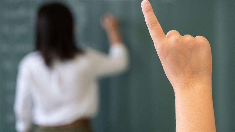 Kultusministerin Hamburg informiert über neues Schuljahr Ein Schüler meldet sich, während die Lehrerin an die Tafel schreibt.