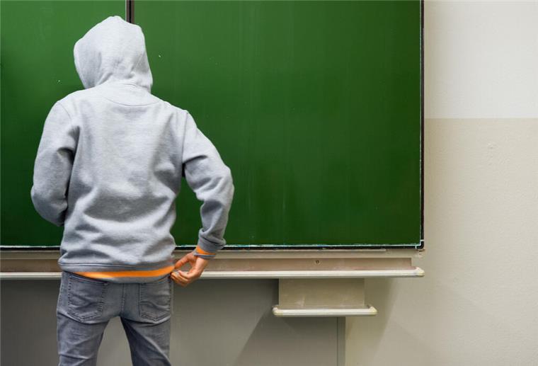 Gewalt an Schulen: Immer mehr Schüler bringen Waffen mit Ein Schüler steht vor einer Tafel.