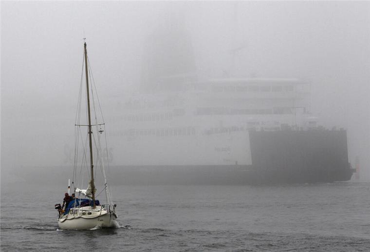 Geister-Nebel auf der Nordsee: Badegäste in Gefahr! Ein Segelschiff und ein Containerschiff auf der Nordsee.