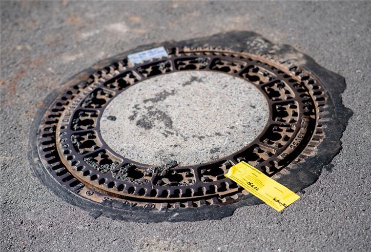 Ein Siegel der Polizei klebt im Stadtteil Donnerschwee auf einem Gullydeckel, unter dem der vermisste Jungen Joe lebend gefunden wurde.