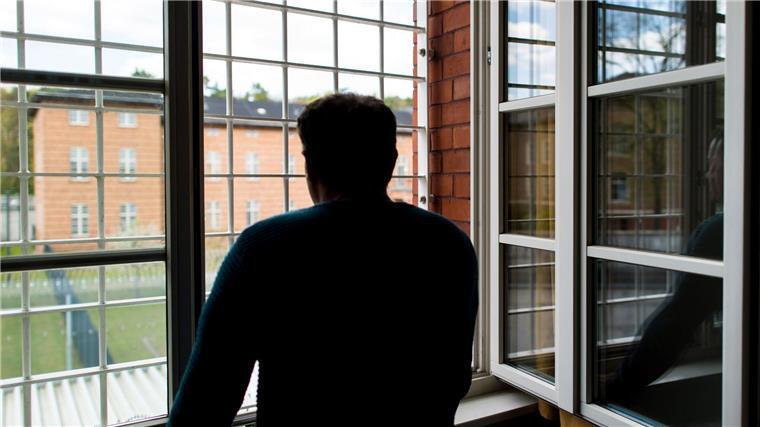 Bremer Senat entscheidet über Maßregelvollzug Ein Straftäter steht vor einem vergitterten Fenster in einer Klinik für Forensische Psychiatrie.
