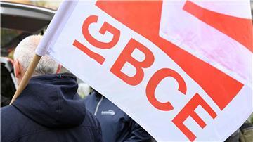 Ein Streikender hält eine Fahne der Gewerkschaft IG BCE in der Hand.