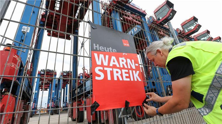 Neues Angebot im Tarifkonflikt bei Seehäfen Ein Streikender hängt ein Plakat am Hamburger Hafen auf. (Archivfoto)