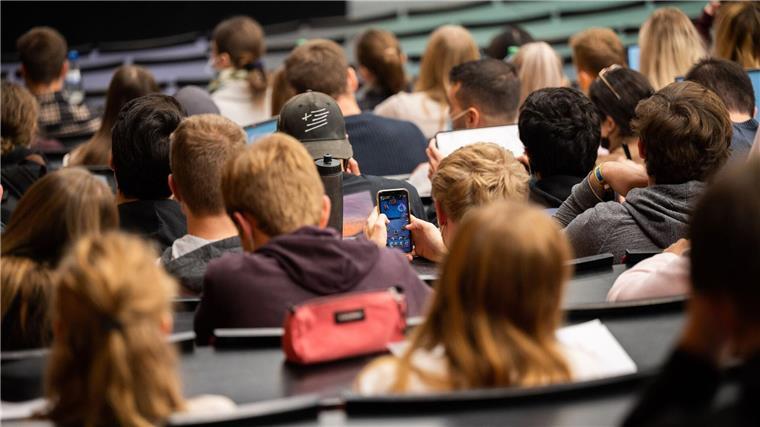 Weniger Studienanfänger ohne Abitur in Niedersachsen Ein Student spielt am Smartphone während einer Vorlesung.