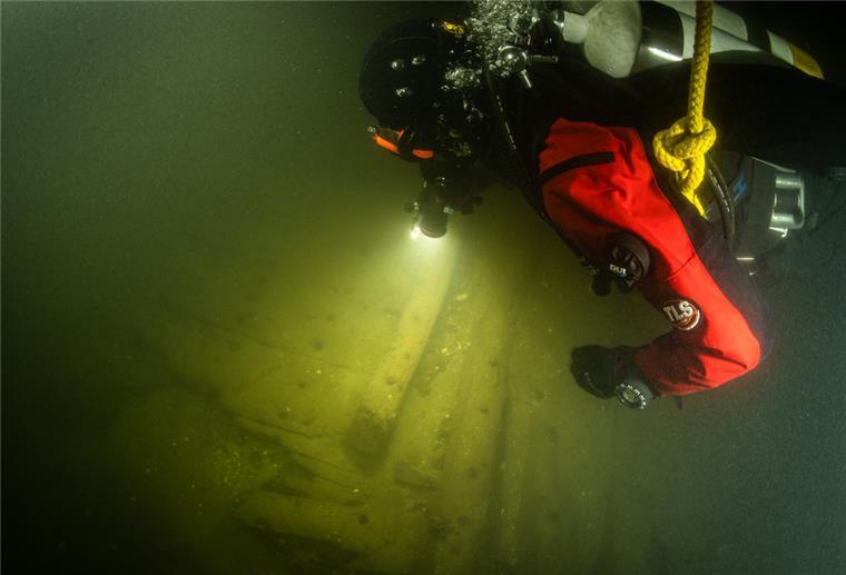 Lübecker Sensationsfund schlägt auch in Bremerhaven Wellen Ein Taucher benutzt in der Trave bei der Begutachtung von Planken eines Schiffswracks eine Unterwasserlampe. Taucher haben auf dem Grund der Trave ein rund 400 Jahre altes Wrack eines Hanseschiffes aus dem 17. Jahrhundert entdeckt.