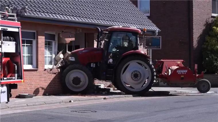 Ein Traktor steckt in einer stark beschädigten Hauswand. Wich der Fahrer einem Schulbus aus? 