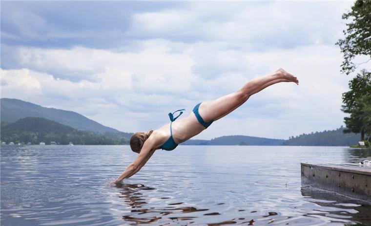 Spaden: Das wird die große Sommer-Überraschung 2019! Junge Frau im blauen Bikini springt in den Spadener See der Blue Bay.