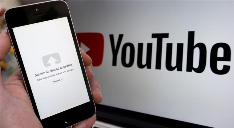 Uploadfilter: EU beschließt umstrittenes Urheberrecht Ein Upload-Fenster der Video-Plattform Youtube ist auf einem Smartphone vor einem YouTube-Logo auf einem Bildschirm zu sehen.