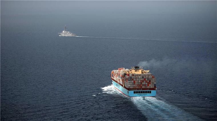 Containerschifffahrt im Roten Meer rückläufig Ein US-Lenkwaffenzerstörer begleitet ein Handelsschiff, das mit Containern beladen ist.