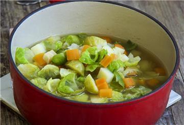 Eine Schüssel mit Hühnersuppe steht auf einem Tisch.