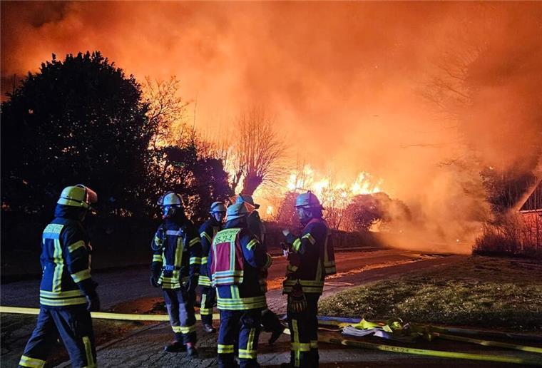 Millionen-Schaden: Historische Reetdachhäuser bei verheerendem Feuer zerstört Feuerwehrleute stehen vor brennenden Häusern. Ein verheerendes Feuer in Dollern hat drei Gebäude zerstört.