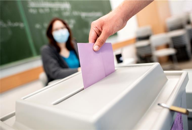 Ein Wähler wirft in einem Wahllokal, das im Klassenraum einer Schule untergebracht ist, seinen Stimmzettel für die Kommunalwahl in die Wahlurne.