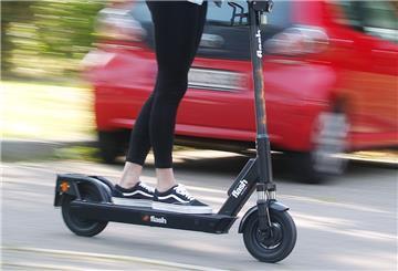 Eine Frau fährt mit einem E-Scooter.