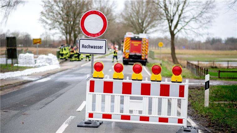 Eine Absperrbake und ein Schild mit der Aufschrift „Hochwasser“.