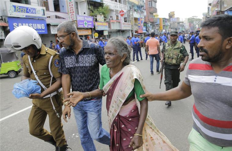 Terroranschläge in Sri Lanka: Mehr als 100 Tote nach Explosionen Eine ältere Frau wird in der Nähe des Explosionsort in St. Anthony's Shrine in Colombo in Sicherheit gebracht. Bei Explosionen in Kirchen und Luxushotels in Sri Lanka sind mehrere Menschen getötet und mindestens 160 Menschen verletzt worden.