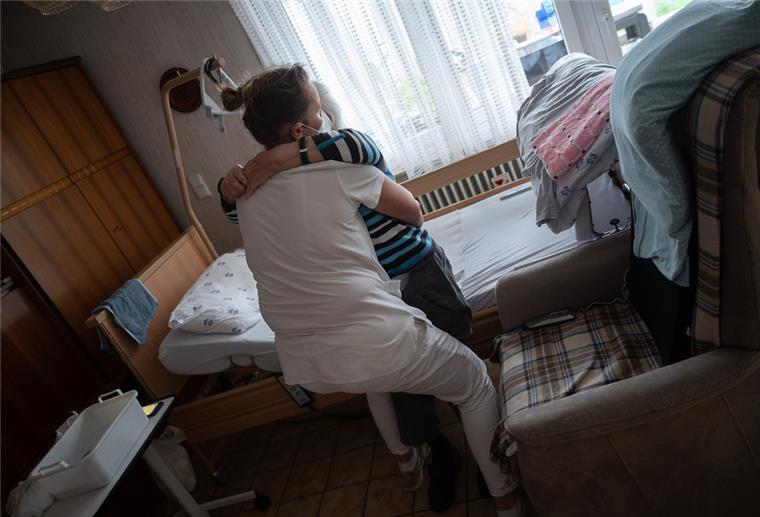 Personalnot in der Pflege: Fachmann aus Zeven hat Ideen Eine ambulante Pflegerin bandagiert die Beine eines alten Mannes. Im Landkreis Rotenburg ist es zunehmend schwierig, Menschen für solche Tätigkeiten zu finden.