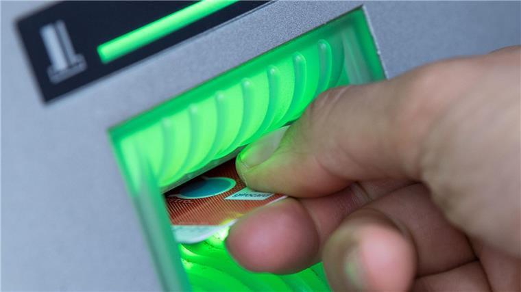 Geldautomatenknacker scheitern an Vernebelungsanlage Eine Bankkundin steckt ihre Girokarte in einen Geldautomaten.
