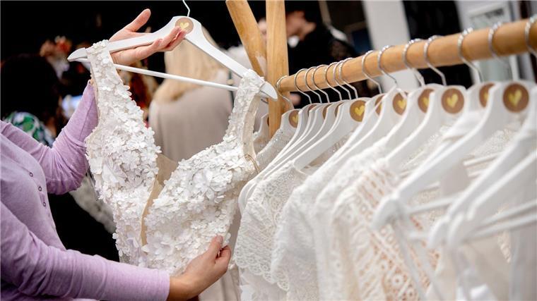 Schlichtes Kleid: Hochzeitsmesse zeigt Trends Eine Besucherin betrachtet Brautmode-Kreationen an einem Stand auf der Hochzeitsmesse.