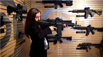 Eine Besucherin demonstriert auf der Messe Defence Security Equipment International (DSEI) in London ein Automatikgewehr. (Archivbild)