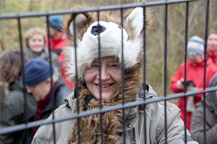 Demo gegen Wildschweinzaun an der deutsch-dänischen Grenze Eine Demonstratin gegen den Wildschweinzaun mit einer Wolfsmütze auf dem Kopf steht am Zaun nahe der deutsch-dänischen Grenze.